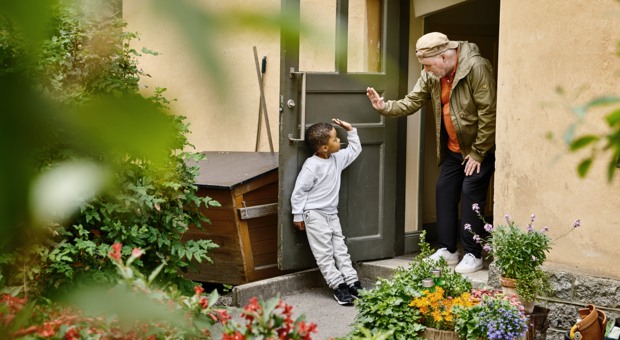 Två grannar hälsar på varandra.