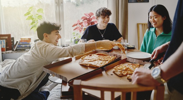 Vänner delar på pizza efter flytten.