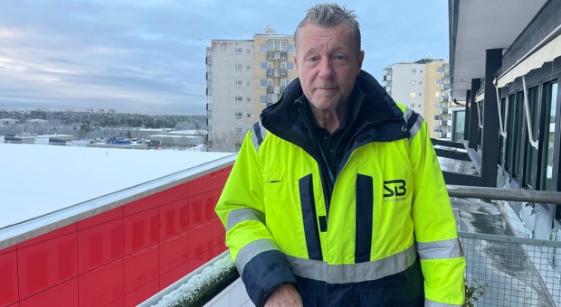 Lars står lutad mot ett balkongräcke en vintermorgon.